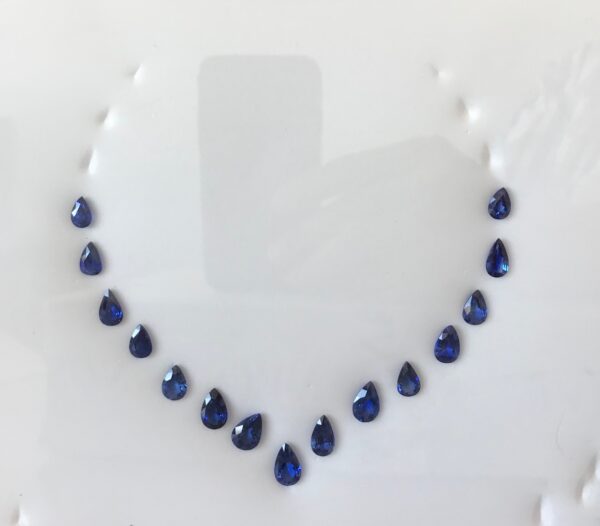 A blue sapphire necklace on a white plate.